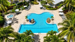 A large swimming pool surrounded by palm trees and lounge chairs. - The Fairway Retreat at GreenLinks (Naples)