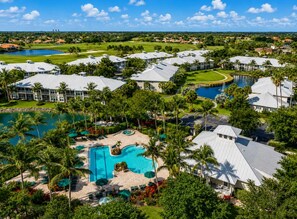 Ein Resort mit mehreren Gebäuden, einem großen Schwimmbad und Palmen.