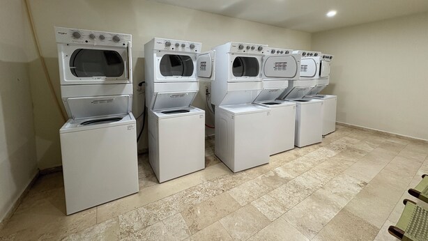 A laundry room with four stacked washer-dryer units. - Studio in the heart of Tulum with rooftop pool - Solum Living (Tulum)