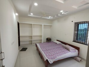 Une chambre à coucher avec un lit, une armoire, une fenêtre donnant sur un beau paysage et un ventilateur de plafond.