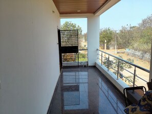 A balcony with a metal railing, a tiled floor, and a view of the surrounding area. - 2 bed 2 bath villa close to the Rajiv Gandhi International airport shamshabad (Hyderabad)