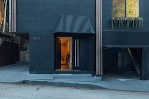 A modern house with a dark facade, a visible entrance, and a number '8329' on the wall. - Luxury Wellness Retreat with Cedar Sauna, Cold Plunge, Gym and Outdoor Oasis (Los Angeles)