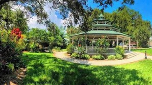 Un belvédère doté d’un toit, entouré d’une végétation luxuriante et d’arbres.