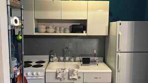 A compact kitchen with a stove, sink, and refrigerator. - Comfortable 1BR Condo in Downtown (Fort Worth)