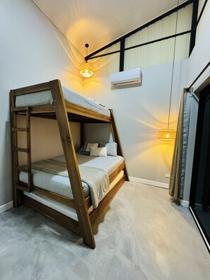 A bunk bed with a ladder, a ceiling light, and an air conditioning unit. - Luxury 2-bedroom suite with AC, BBQ, and pool in Pinilla Tamarindo (Pinilla)