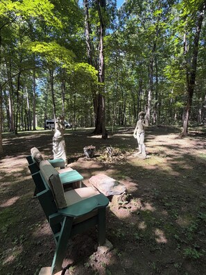 Ein Campingplatz mit einer Bank, einem Picknicktisch und zwei Statuen.