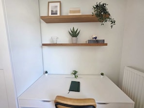 A white desk with a chair, two shelves with plants and books, and a framed picture on the wall. - Premium 2BR Apartment w balcony&parking (Luxembourg)