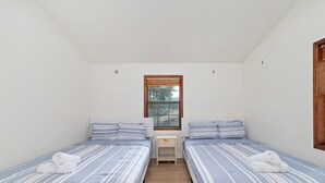 A small, clean room with two single beds, a window, and a wooden door. - Lara Retreat- 6B/4.5 BT- Private Pool and Paris- Game room (Houston)