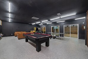 A pool table with a red felt surface, a billiards cue, and a pool rack with balls. - Lara Retreat- 6B/4.5 BT- Private Pool and Paris- Game room (Houston)