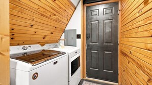 A compact kitchen with a stove, oven, and a wooden door.