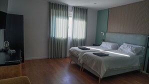 Hotellihuone, jossa on sänky, työpöytä ja tuoli.