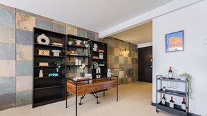 A modern interior with a desk, bookshelf, and wine rack. - Two Roma Norte Condos with City Views & Workspace (Ciudad de México)