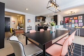 Een moderne eetruimte met een lange tafel, stoelen en een decoratieve vaas.