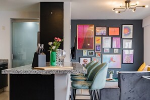 Eine moderne Küche mit einer Granit Arbeitsplatte, einem grünen Blumenvasen und einem Weinglas.
