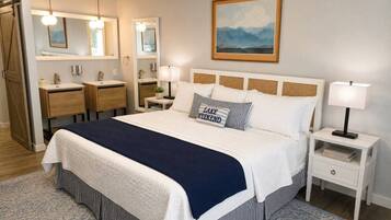 Hotelkamer met een groot bed, nachtkastjes, een kledingkast en een schilderij aan de muur.