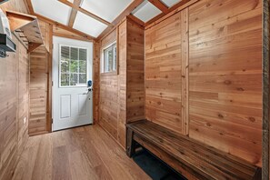 A wooden interior with a door, bench, and window. - WHITETAIL CROSSING – 4 Bedroom Cabin with Lake and Trail Access (Saint Germain)