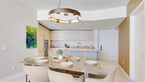 A modern dining area with a central island, chairs, and a pendant light. - 2BR Ocean Views & Modern Comfort (Hollywood)