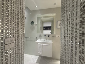A modern bathroom with a glass shower enclosure, a white sink, and a mirror above it. - Sisto Suite - Charming 1-bedroom apartment with AC in vibrant Roma (Roma)