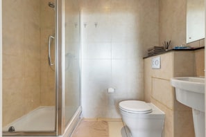 Ein Badezimmer mit Duschkabine, Toilette und Waschbecken.