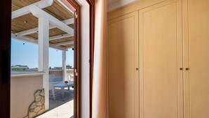 A room with a large wardrobe, a covered outdoor seating area, and a view of the outside. - AgoRattico – Elegant Penthouse with Panoramic Terrace (Quartu Sant'Elena)