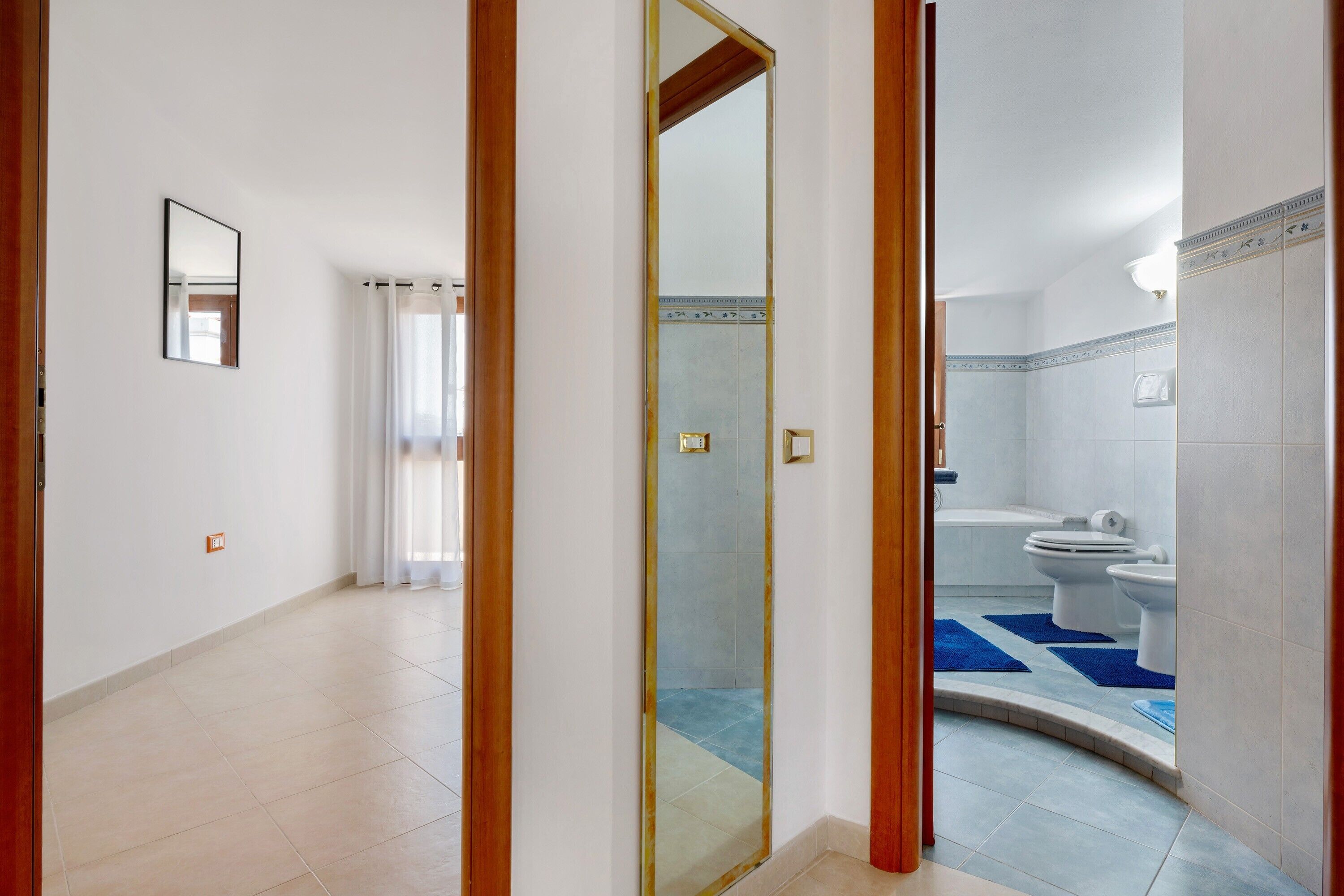 Habitación de hotel con baño que incluye una bañera, inodoro y lavamanos.