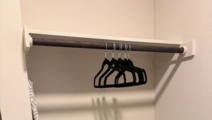 Ein Kleiderschrank mit Kleiderstange, Bügelbrett und Ablagefläche.