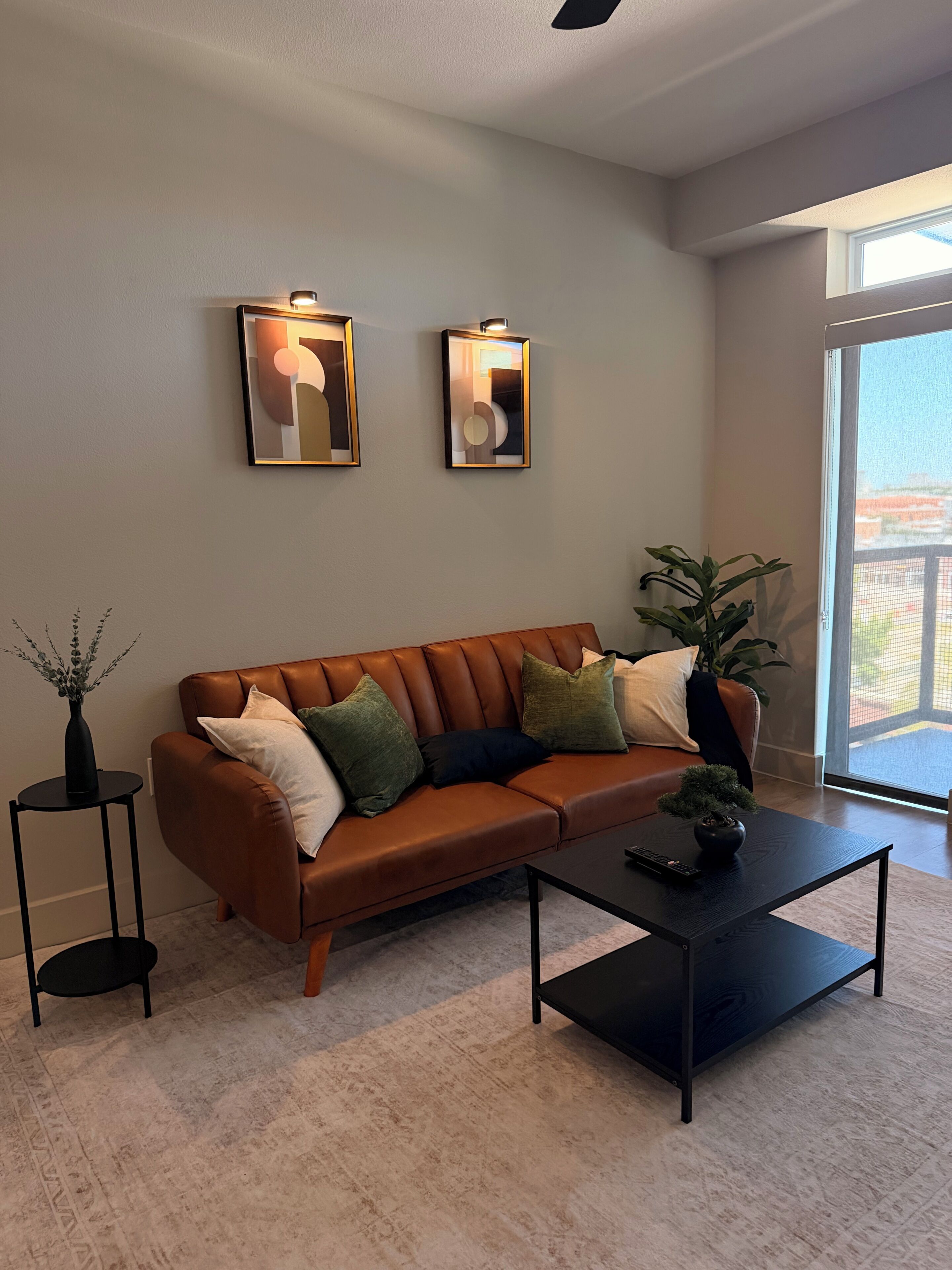 Un salon moderne avec un canapé en cuir, une table basse et deux appliques murales.
