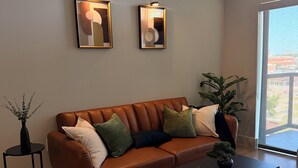Ein modernes Wohnzimmer mit einer Ledersofa, einem Couchtisch und zwei Wandleuchten.