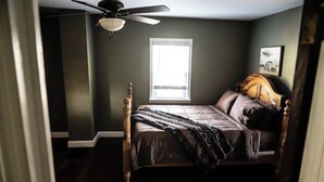 Ein Schlafzimmer mit Bett, Fenster und Deckenventilator.