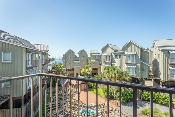 A residential area with multiple two-story buildings, a wooden deck, and a swimming pool.