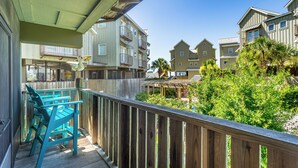 A wooden deck with a view of multi-story buildings and greenery. - Cozy Condo with River views (Carrabelle)