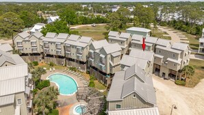 A residential complex with multiple apartment buildings, a swimming pool, and a dock. - Cozy Condo with River views (Carrabelle)
