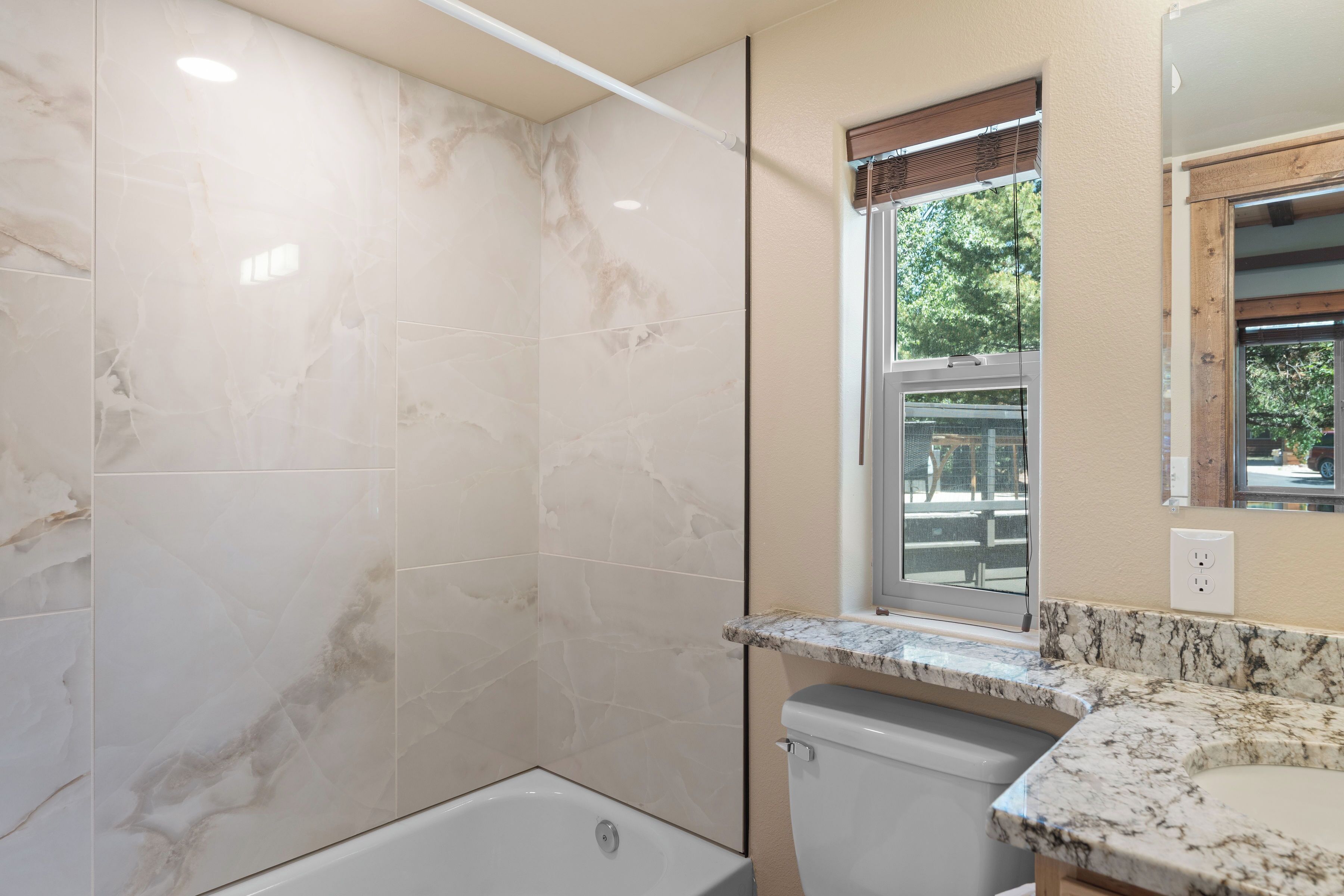 A bathroom with a shower, toilet, and sink.