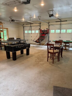 A recreational room with a foosball table, a ping pong table, and a small basketball hoop. - Welcome to Bud and Jacquie Sue’s (Sterling)