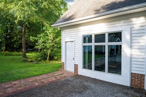 A house with a white exterior, a brick foundation, and a gravel driveway. -  2-bedroom guest house in Upstate, SC (Easley)