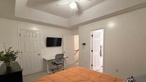 A bedroom with a bed, a desk, a chair, and a television on the wall. - 2 bedroom furnished townhome, washer & dryer, Central Air, Wifi & New appliances (Atlanta)