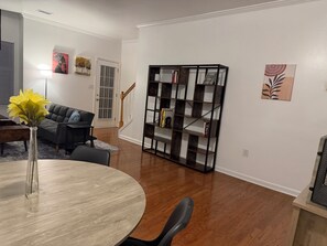 A living room with a round table, a sofa, a bookshelf, and a vase with flowers. - 2 bedroom furnished townhome, washer & dryer, Central Air, Wifi & New appliances (Atlanta)