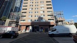 Un immeuble résidentiel de grande hauteur, à plusieurs étages, avec une façade en briques et un toit plat.