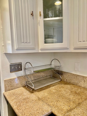 A kitchen with white cabinets, a stainless steel sink, and a granite countertop. - Cozy 1-bedroom house in peaceful Los Angeles with AC (Los Angeles)