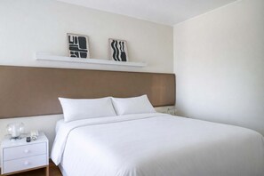 A hotel room with a bed, a nightstand, a bedside table, and two wall-mounted artworks. - 3 APTS in One Building · Ideal for Large Groups! (Miraflores)