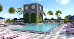 Ein Poolbereich mit Liegestühlen, einer dekorierten Poolkante und einem Gebäude mit Rundbogenfenstern.