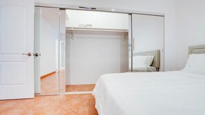 Ein Hotelzimmer mit einem Bett, einem Kleiderschrank und einem Spiegel.