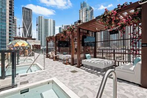 A rooftop lounge with a pool, seating areas, and a view of the city skyline. - Luxury Studio | Prime Downtown Views (Miami)