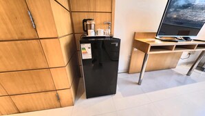 A compact kitchenette with a refrigerator, a coffee maker, and a small table with a laptop. - Hotel Pascana centro (Santa Cruz)