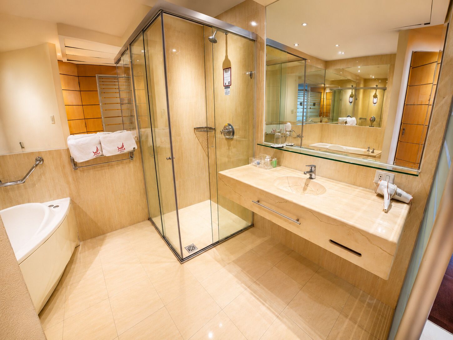 A modern bathroom with a glass-enclosed shower, a bathtub, and a vanity with a large mirror.
