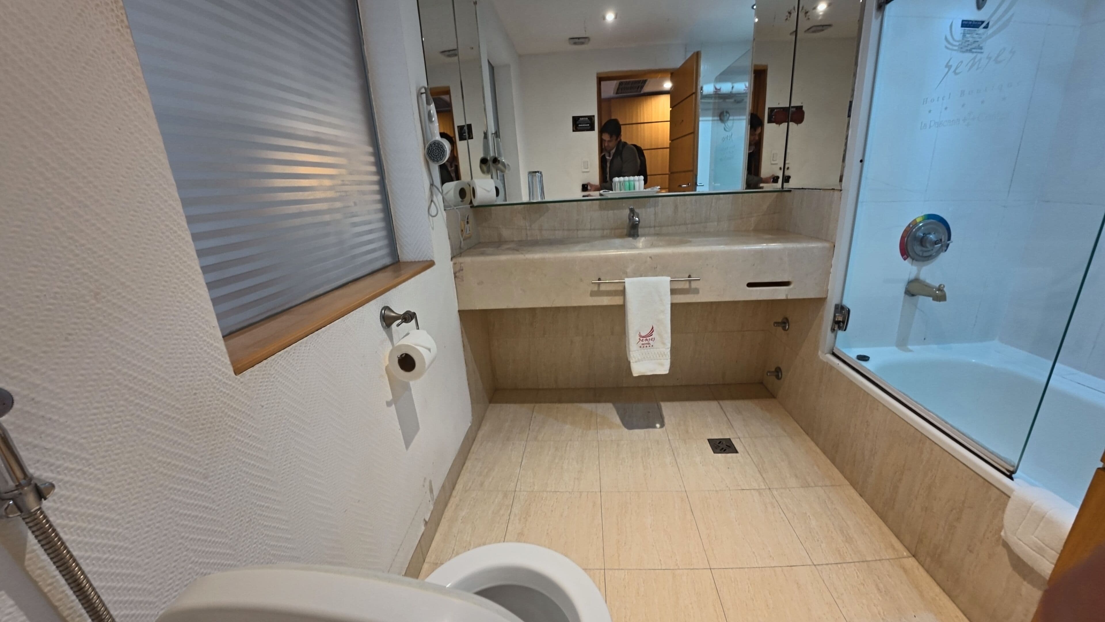 A bathroom with a toilet, sink, and shower.