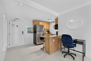 Una cocina moderna con refrigerador, armarios de madera y una pequeña isla.