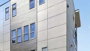 Monikerroksinen rakennus, jossa on moderni arkkitehtoninen ilme ja jossa julkisivussa yhdistyvät vaakasuorat ja pystysuorat linjat.