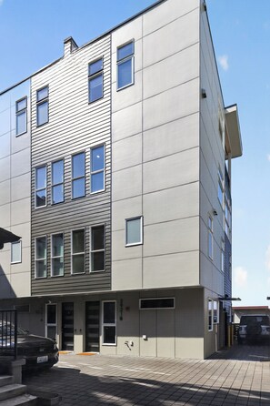 Ein mehrgeschossiges Gebäude mit modernem architektonischen Design, das horizontale und vertikale Linien an der Fassade vereint.
