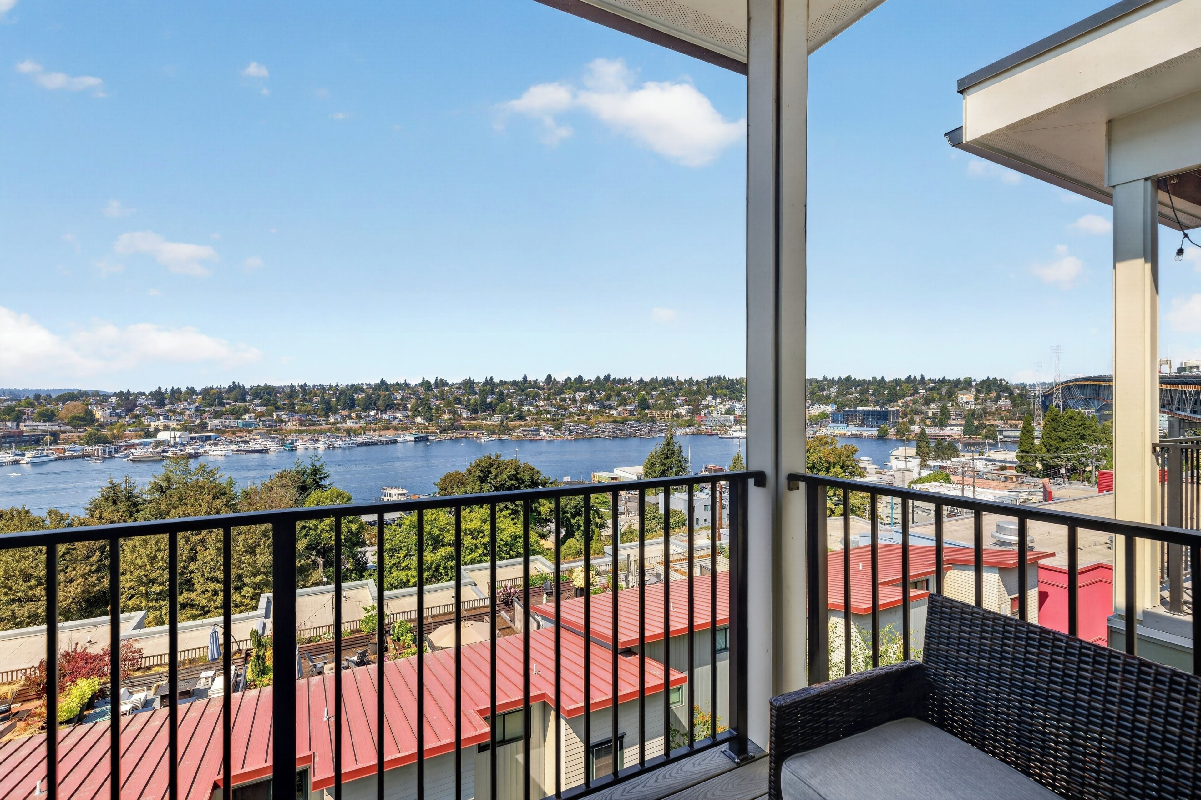 A balcony with a view of a waterfront, including a marina and residential buildings.